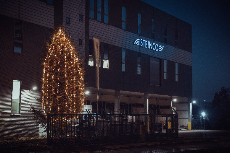Beleuchteter Weihnachtsbaum steht vor STEINCO-Gebäude 